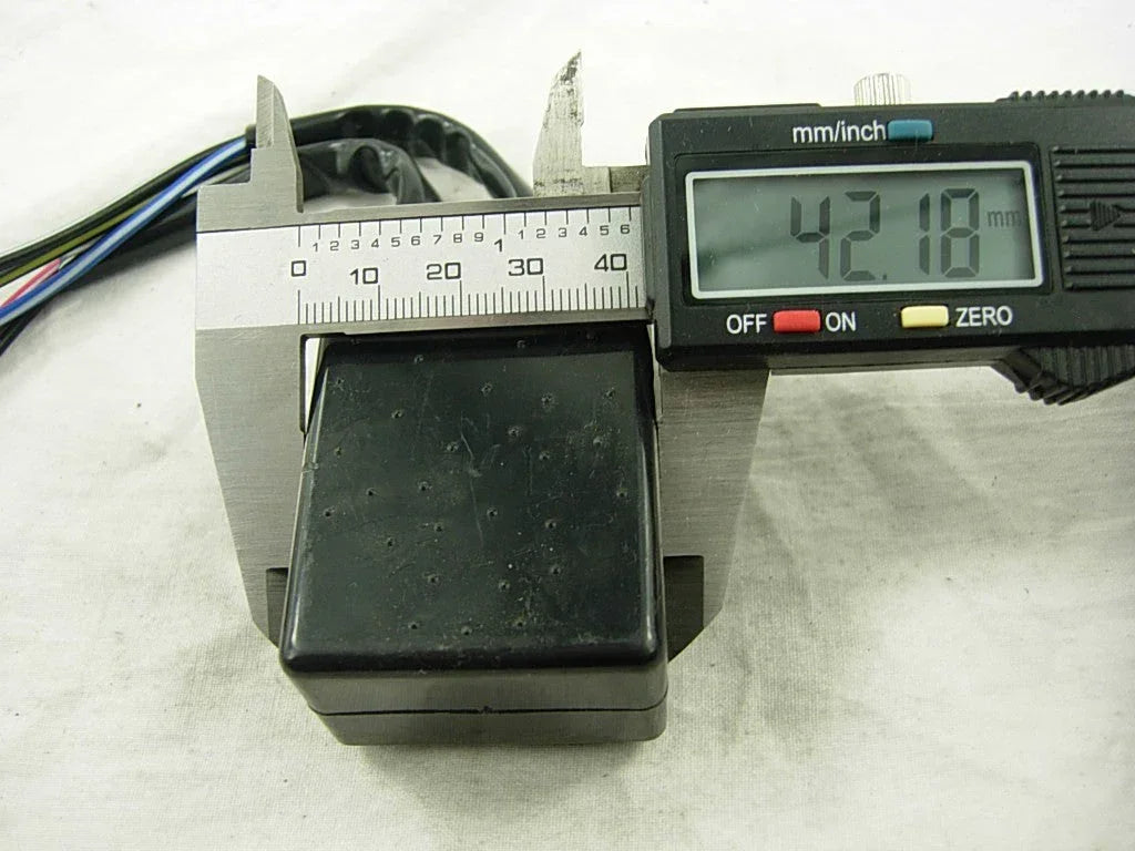 Black motorcycle CDI unit with attached wires measured by digital caliper at 42.18mm