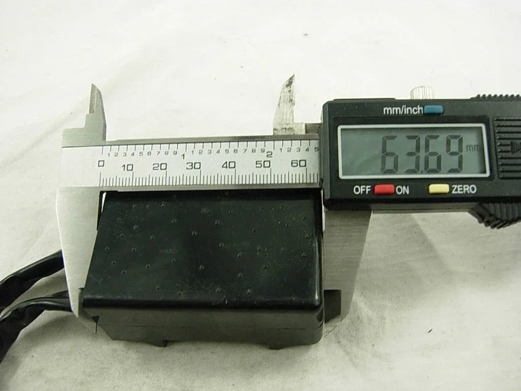 Motorcycle CDI unit box for Suzuki RM250 measured with digital caliper, showing 63.69mm.