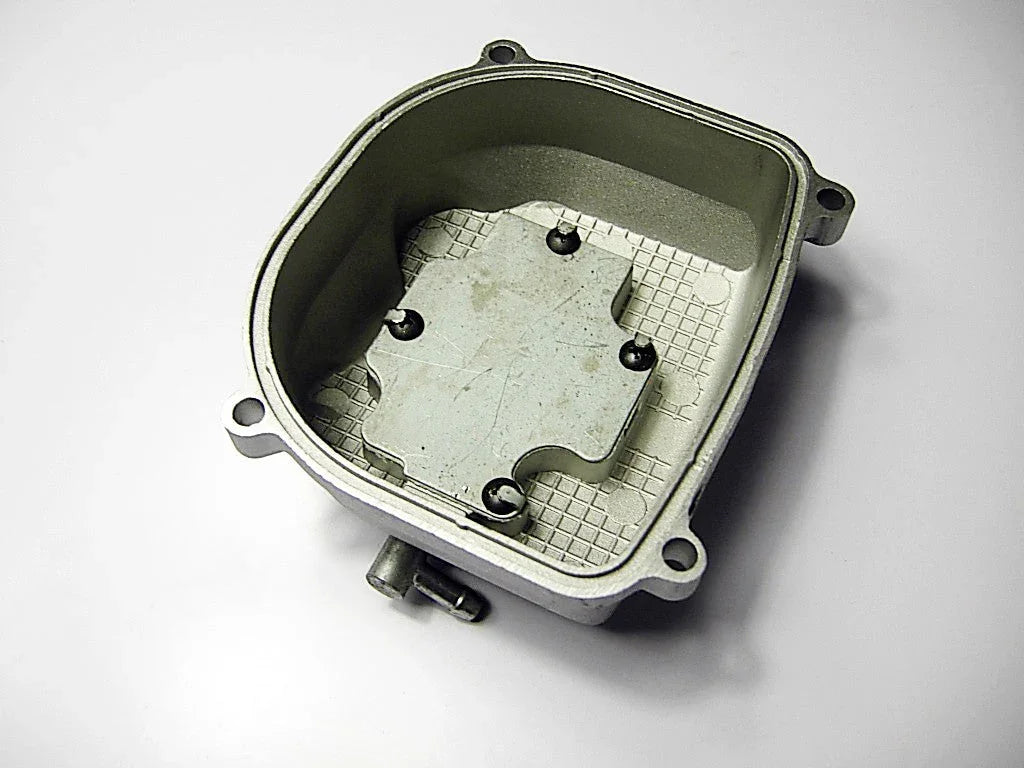 metal automotive carburetor float bowl component with mounting holes on white background