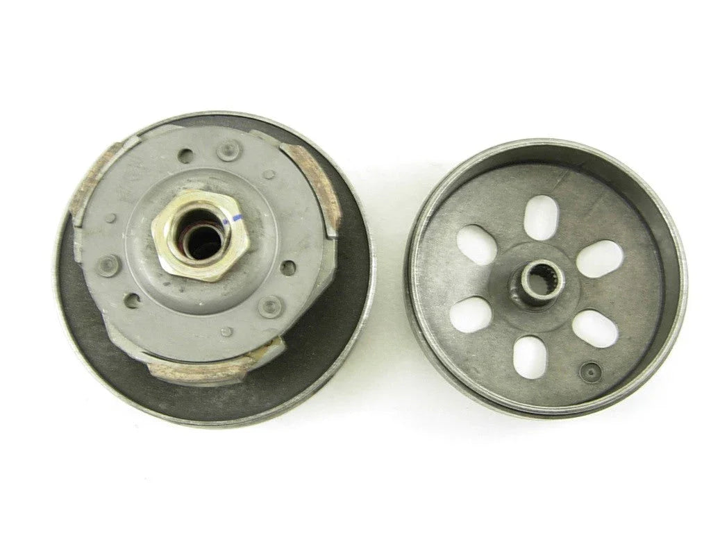 Two metal clutch components for small machinery with central hex nut and circular slots on white background