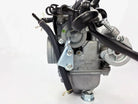 Keihin Japan motorcycle carburetor with attached black hoses and metal fittings on white background