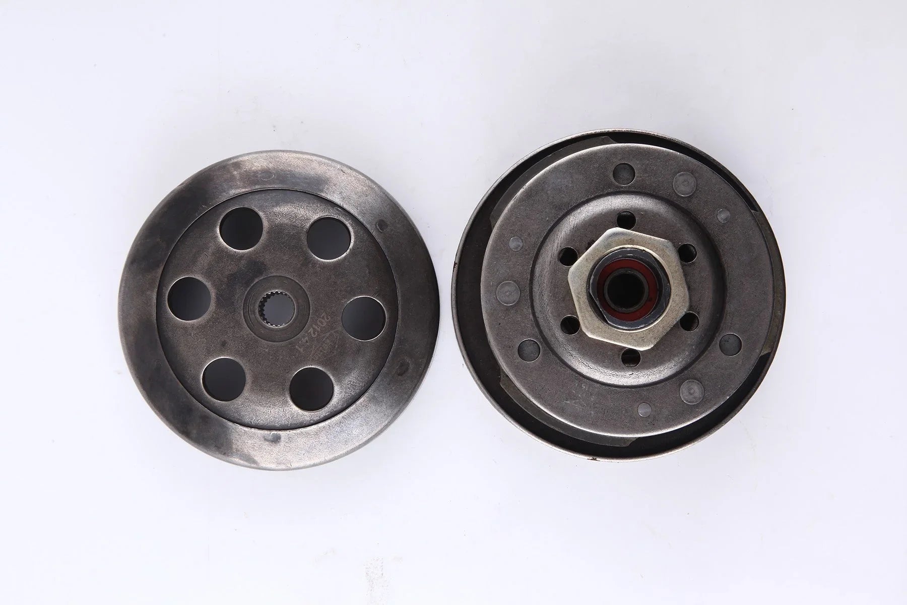 Metal clutch components with circular holes and bolt on white background