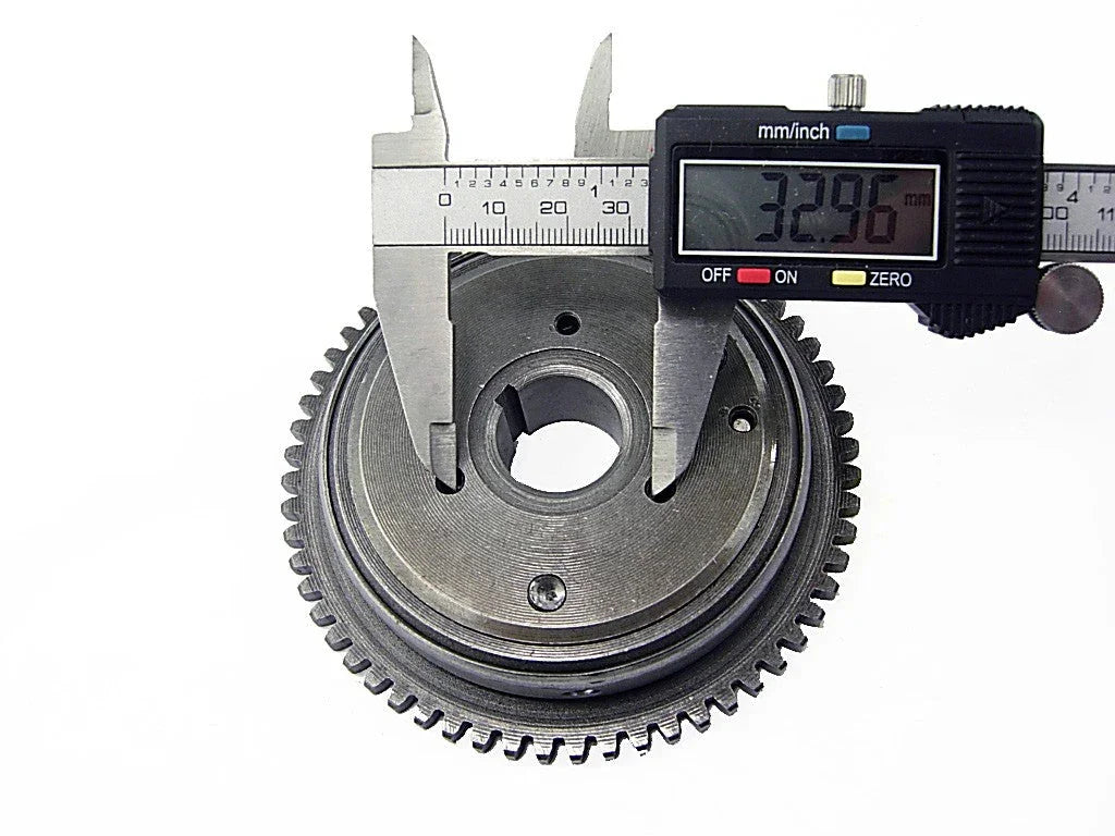 Digital caliper measuring the inner diameter of a metal gear showing 32.96 mm