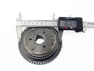Digital caliper measuring a metal gear with 87.11mm diameter on white background