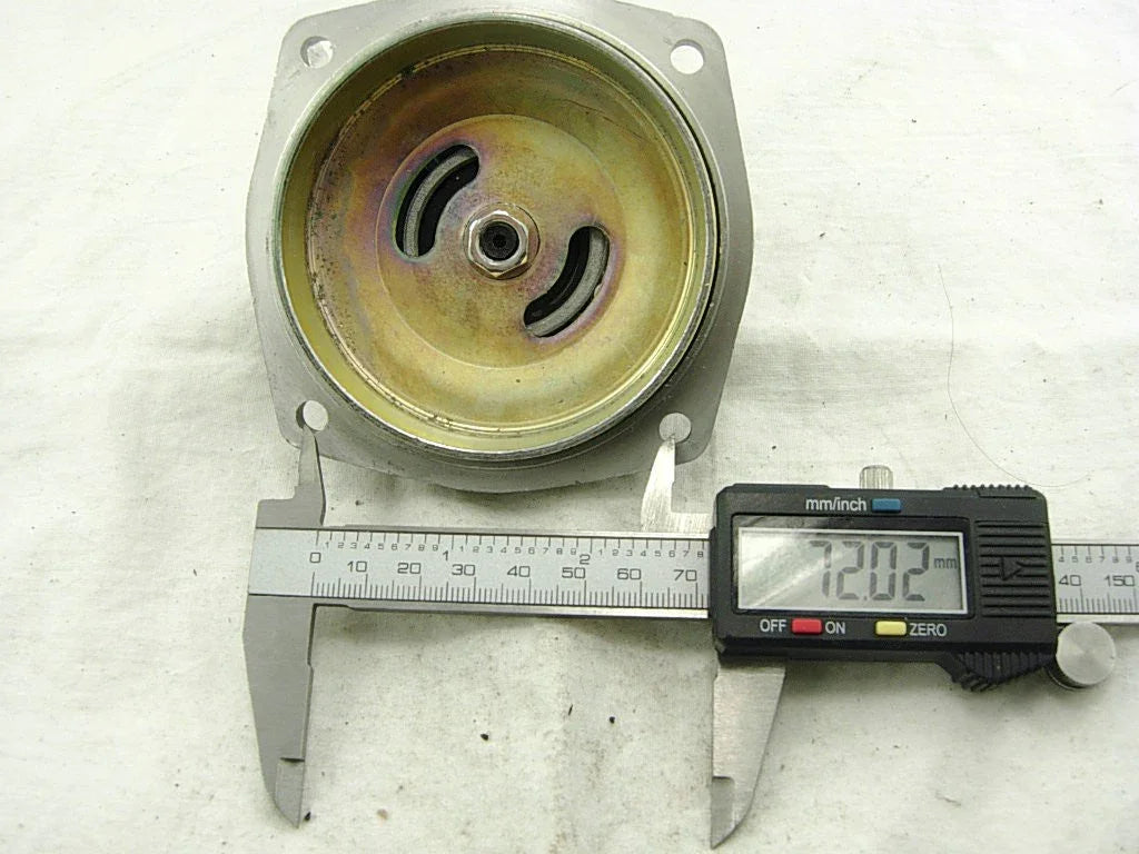 Digital caliper measuring diameter of a round metal mechanical part showing 72.02 mm on display