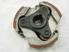 Close-up of a metal centrifugal clutch with three shoes and brown friction material on a white background