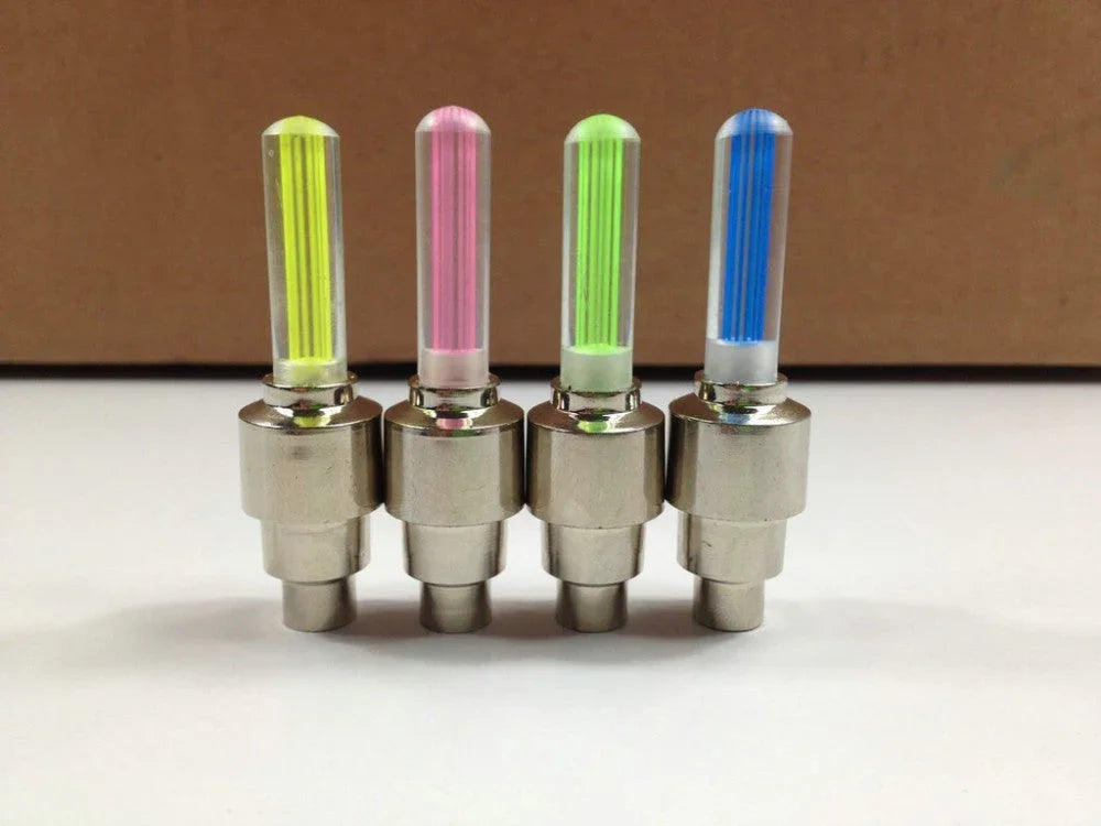 Set of four universal LED tire valve lights in yellow, pink, green, and blue for bikes or cars