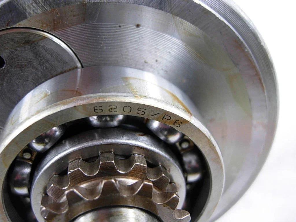 Close-up of metal bearing and gear assembly with ball bearings and engraved markings