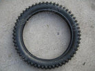 14 inch knobby front dirt bike tire with inner tube on concrete surface