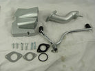 Silver motorcycle engine parts including cover, exhaust pipe, kickstarter lever, gaskets, bolts on white cloth