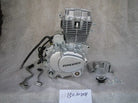 Zongshen 150cc motorcycle engine with components and mounting screws on gray background