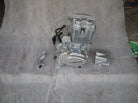 Silver Loncin small motorcycle engine with mounting parts and screws on gray surface