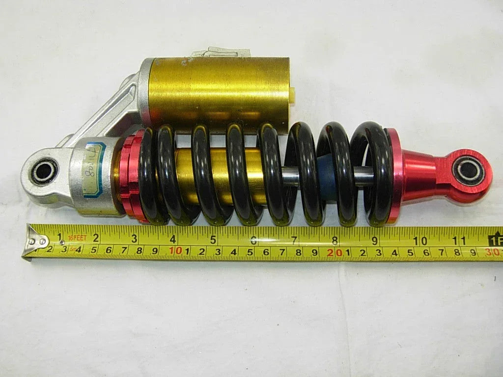 265mm air shock absorber for dirt bikes, durable suspension component from vendor-unknown with metal coil and mounting points