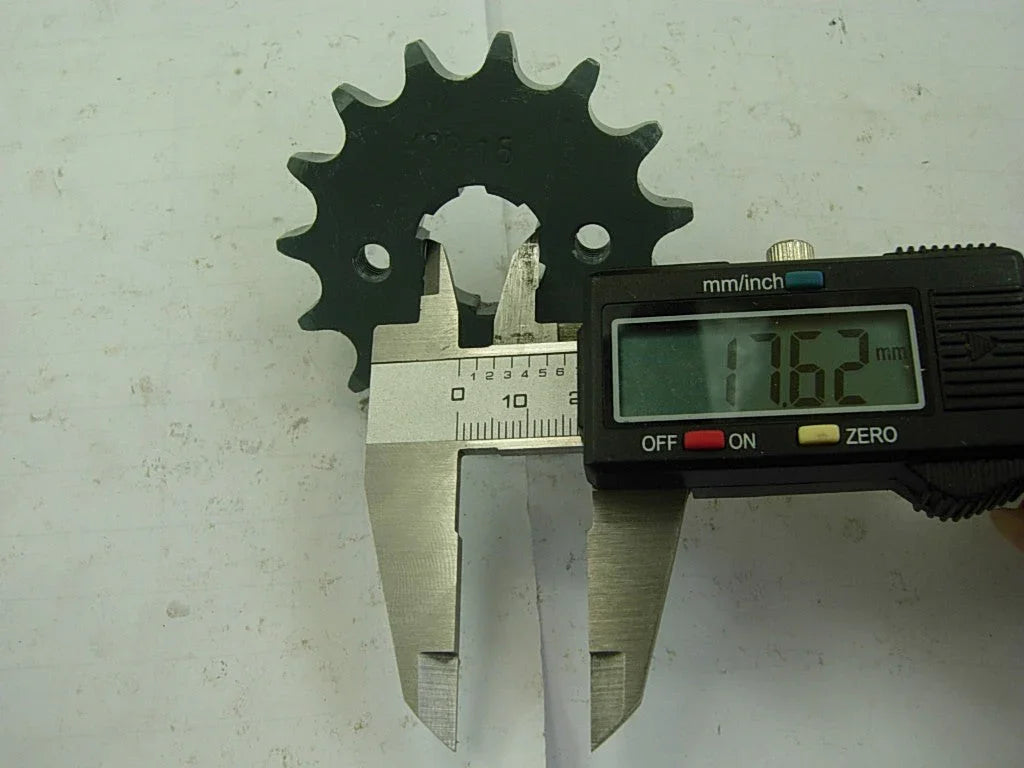 digital caliper measuring 17.62 mm inner diameter of black metal sprocket gear on white surface