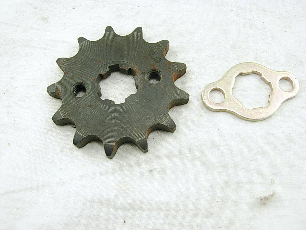 Metal sprocket gear and matching mounting plate on white fabric background