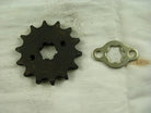 Rusty black metal sprocket gear and silver metal locking plate on white cloth