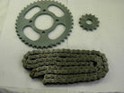 Metal motorcycle sprockets and chain on a white surface, black finish, mechanical parts