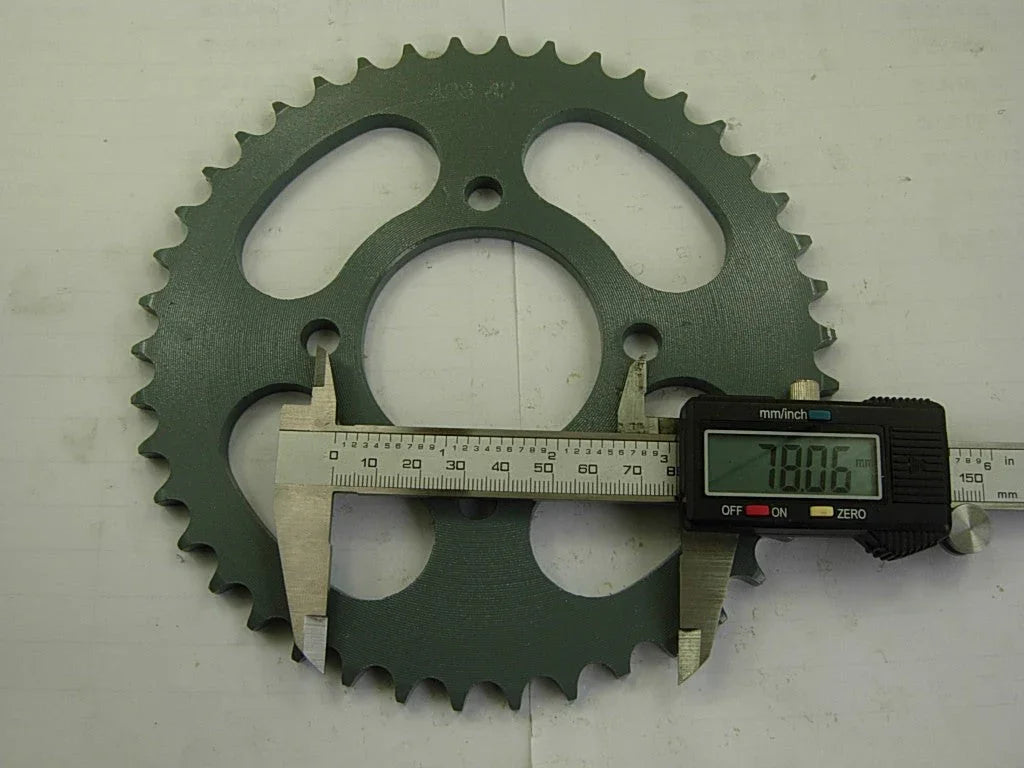 Digital caliper measuring the diameter of a green metal sprocket gear showing 78.06 mm