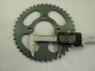 digital caliper measuring 58.11 mm on a green metal sprocket gear with teeth