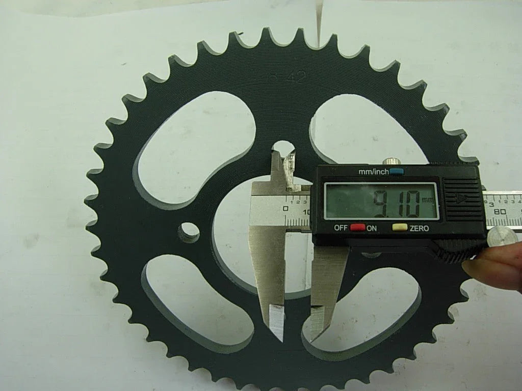 Digital caliper measuring a black 42-tooth bike sprocket thickness of 9.10 mm