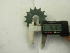 Digital caliper measuring diameter of black metal sprocket gear marked 428-14, showing 18.26 mm