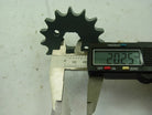 Digital caliper measuring 20.25 mm on a black metal sprocket gear with 12 teeth on white surface