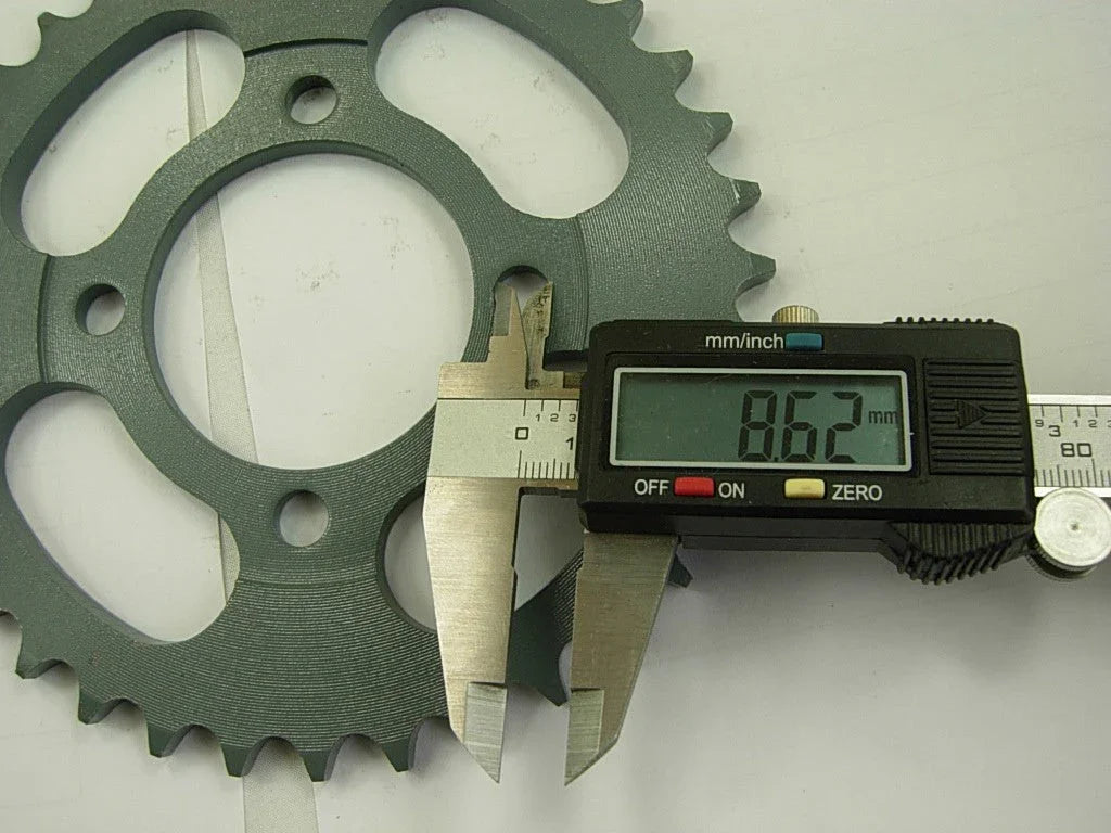 Digital caliper measuring 8.62 mm on a gray metal sprocket gear teeth