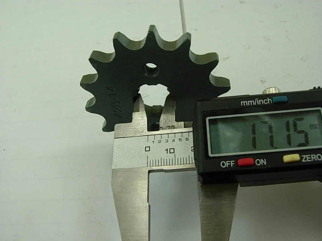 Digital caliper measuring a black metal sprocket gear diameter at 17.15 mm on a white background