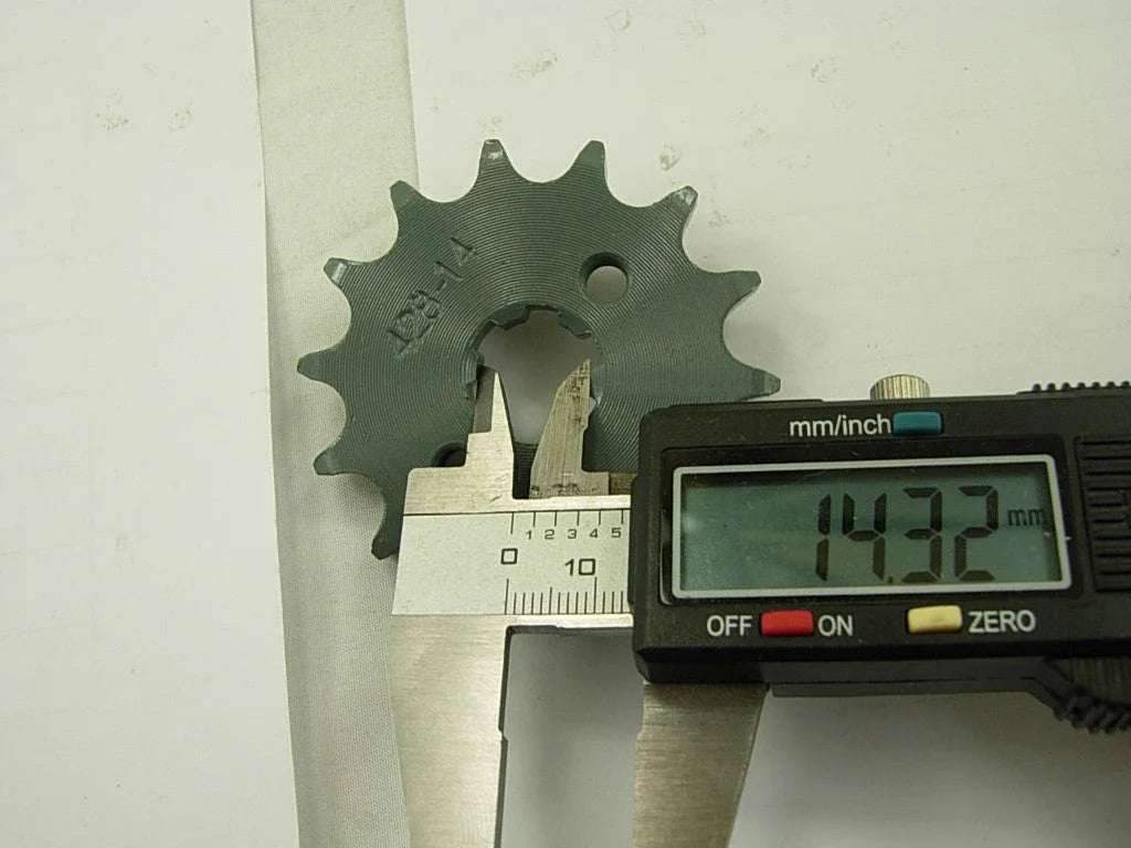 Measuring 14.32mm inner diameter of gray metal sprocket gear using digital caliper on white background