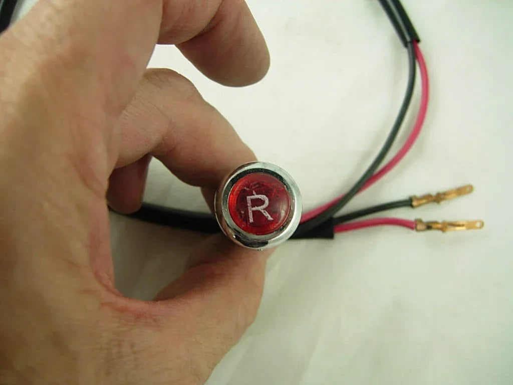 Reverse indicator light for 150cc dirt bike, black plastic housing, mounted on the bike's rear, essential for safety and visibility.