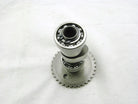 metal camshaft with visible ball bearings and gear teeth on white background