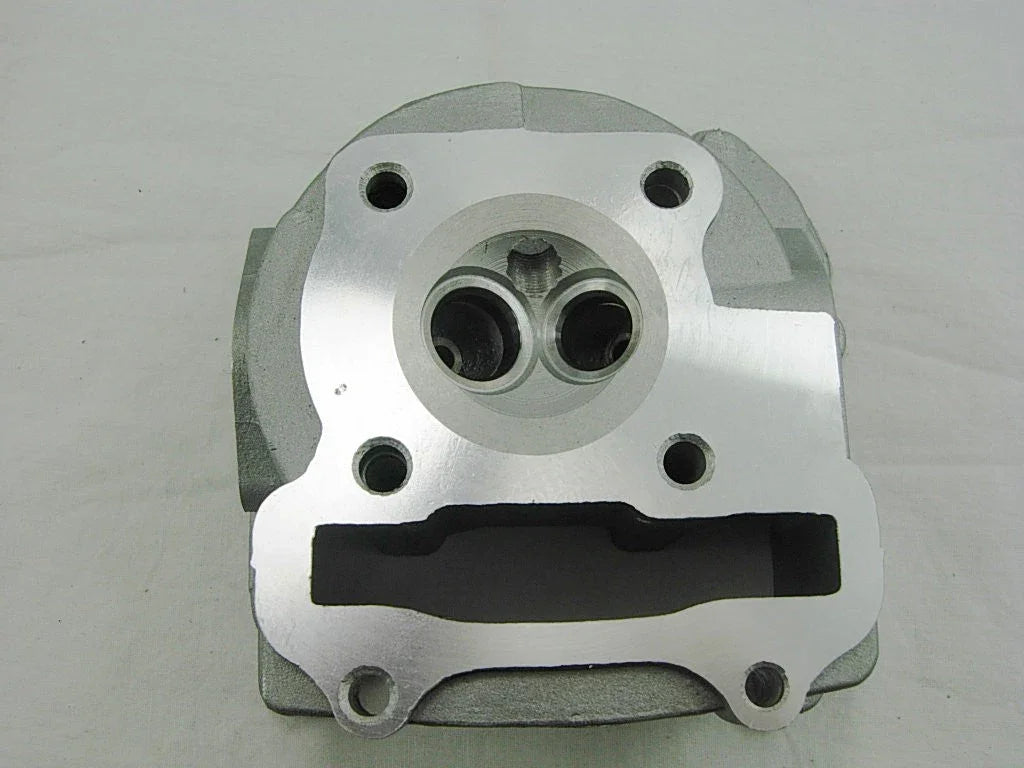 Close-up of shiny metal motorcycle engine cylinder head part on white background