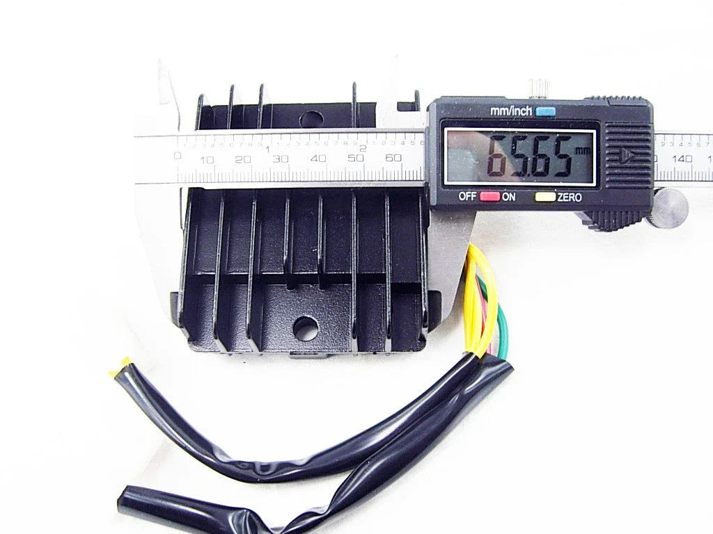 Digital caliper measuring black rectangular electronic component with cooling fins and multi-colored wires