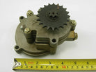 Mechanical metal gear pump with sprocket and bolts above yellow measuring tape