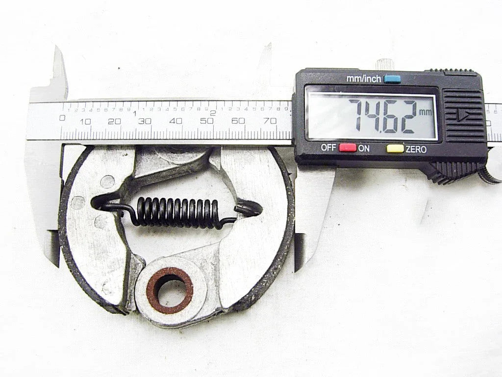 Digital caliper measuring 74.62 mm on a circular metal mechanical spring clutch component