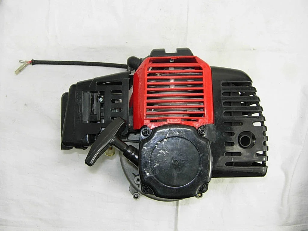 Red and black gas engine starter with pull handle on white background