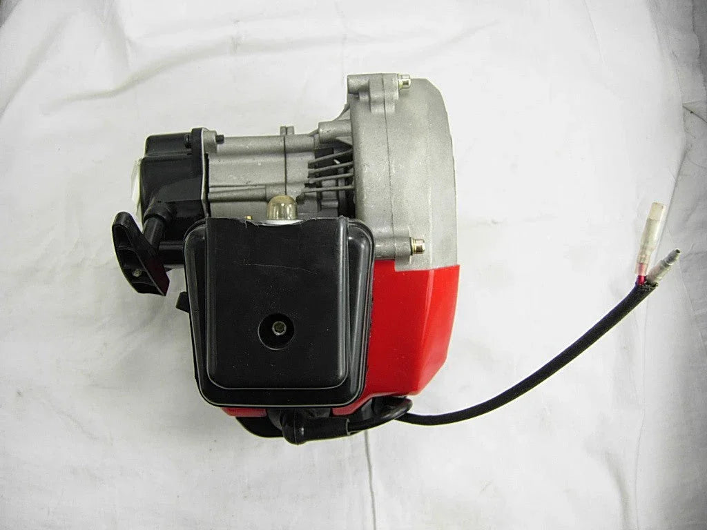 Red and black small gasoline engine with air filter and attached ignition wire on white background