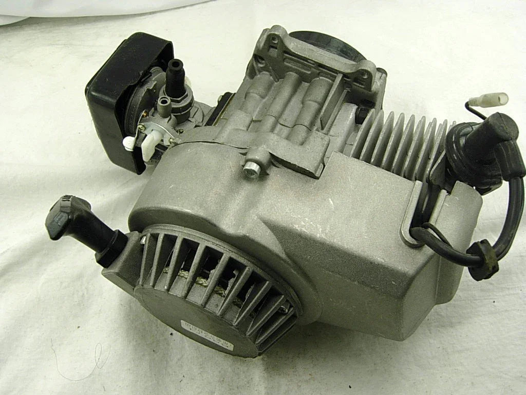 Small air-cooled gasoline engine with recoil starter and carburetor on white background