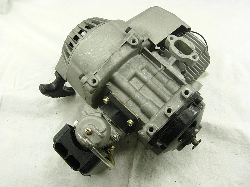 Compact gray small engine with cooling fins and black exhaust pipe on white background