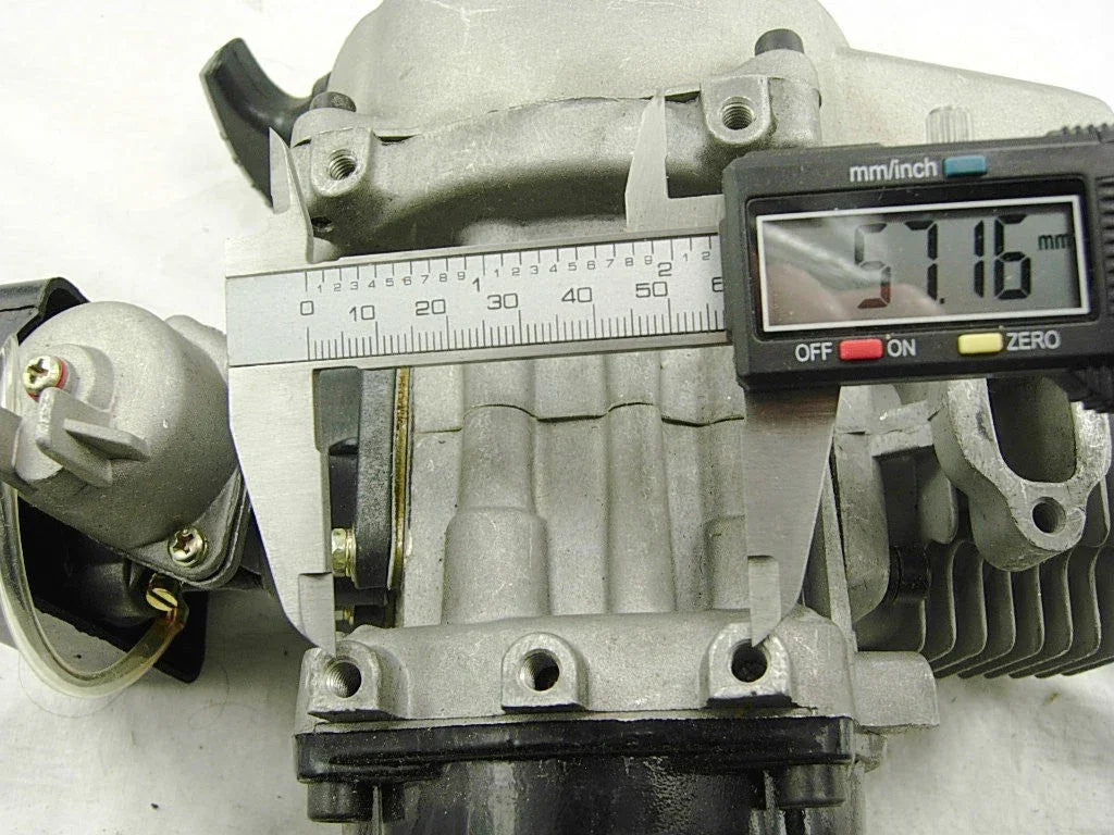 Digital caliper measuring diameter of a silver engine cylinder part showing 57.16 mm