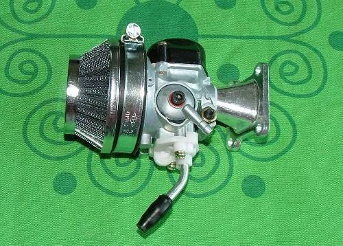 motorcycle carburetor with air filter and intake manifold on green patterned background