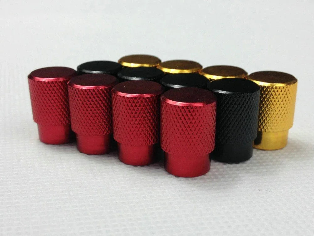 Set of metal tire valve stem caps in red, black, and gold for car or motorcycle wheels